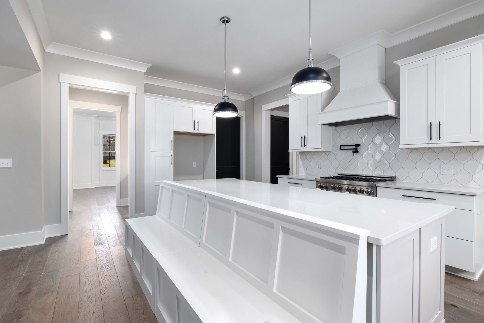 A bright kitchen with clean countertops, a central island and white cabinets